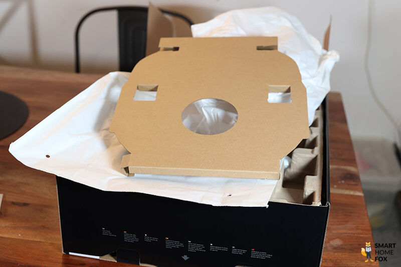 Die plastikfreie Verpackung eines Shark Saugroboters ist zu sehen.